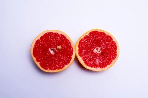 Two fresh red grapefruit halves on white background Stock Photos