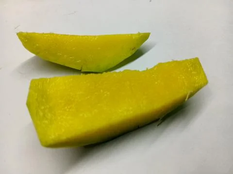 Two fresh sliced green mango pieces on white background. Stock Photos
