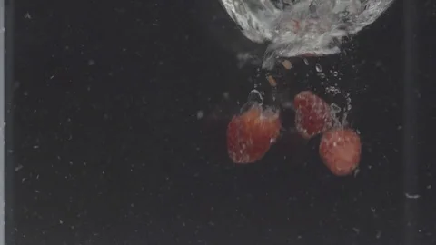 Two fresh strawberries falling in the water Stock Footage 73687728