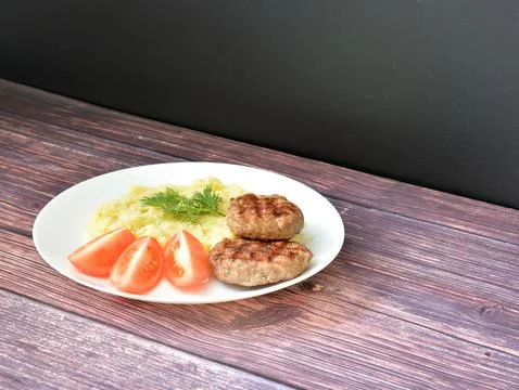 Two fried beef cutlets, mashed potatoes with chopped green onions and piece.. Stock Photos