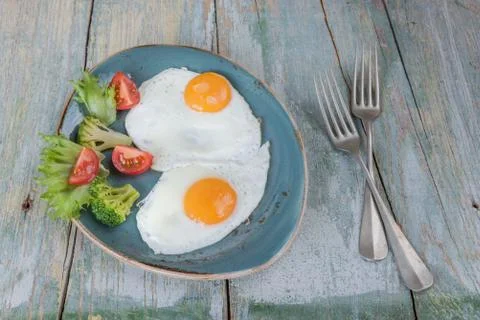 Two fried eggs and vegetables Stock Photos