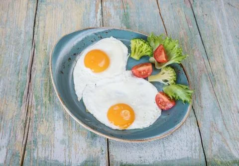 Two fried eggs and vegetables Stock Photos