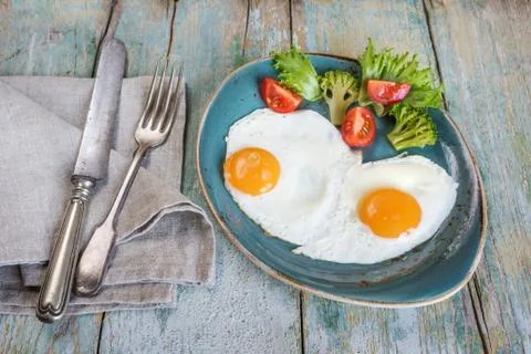 Two fried eggs and vegetables Stock-Fotos
