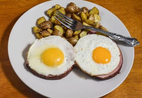 Two fried eggs on ham  with a side of home fries, Stock Photos