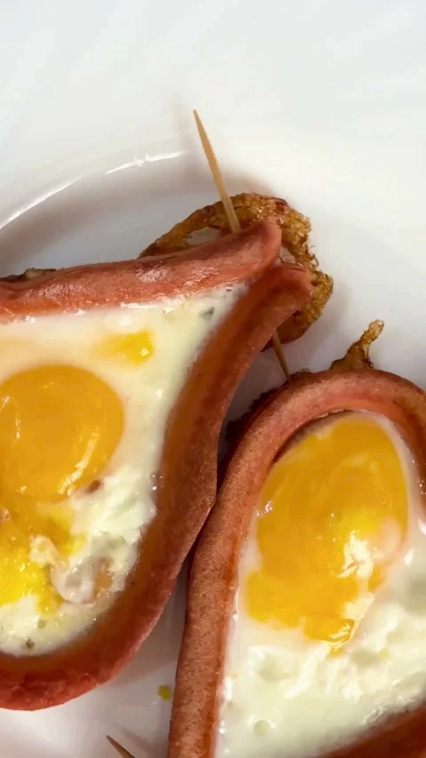 Two fried eggs in heart shaped sausages on plate Stock-Footage 331975507