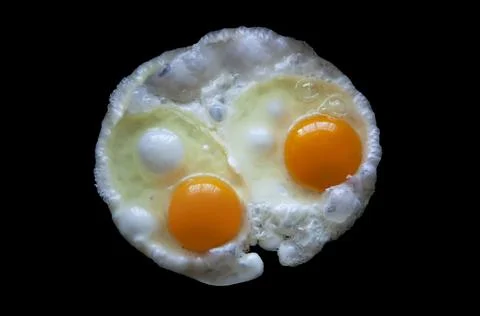 Two fried eggs Isolated on a black background view from above Stock Photos