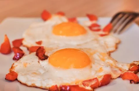 Two Fried eggs on pan with red pepper morning breakfast Stock Photos