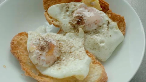 Two fried eggs rest on toasted bread slices Stock Footage 341767405