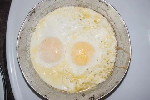 Two fried eggs in a small frying pan Stock Photos