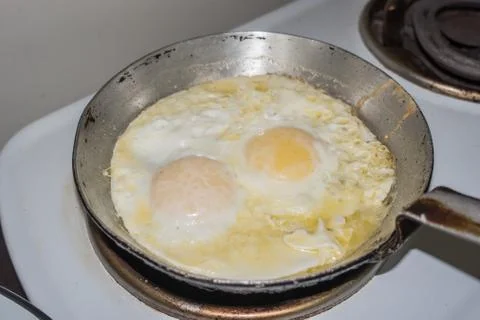 Two fried eggs in a small frying pan Stock Photos