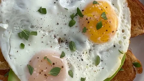 Two fried eggs on toast from overhead Stock Footage 220434981