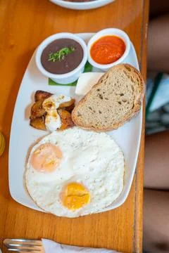 Two fried eggs with various sides at organic healthy breakfast restaurant i.. Foto stock
