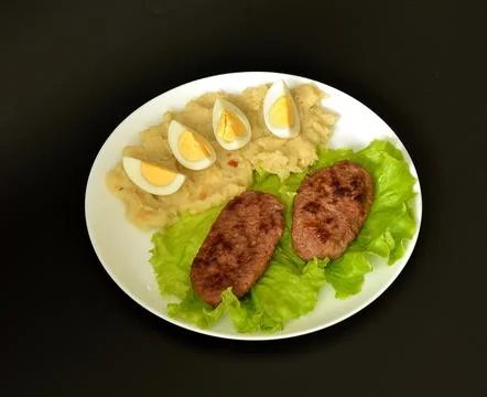 Two fried meat cutlets on a lettuce leaf, mashed potatoes and a boiled egg .. Stock-Fotos