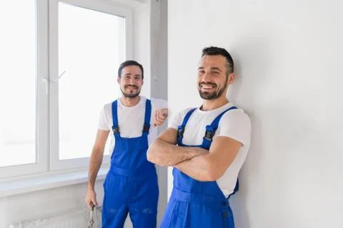 Two friendly builders in overalls smiling Stock Photos