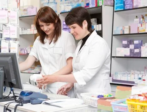 Two Friendly Pharmacists Working Together in the Drugstore . Stock Photos