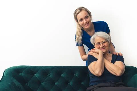 Two friendly women looking at camera. Young doctor being held by her elderly Stock Photos