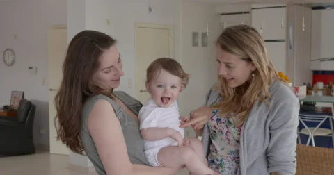 Two friends admiring  1year old child Stock Footage 48626996