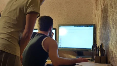 Two friends are discussing something when studying at home. One of them is also Stock Footage 72590377