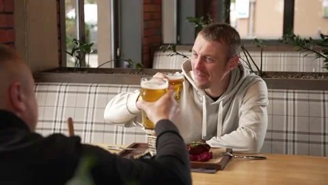 Two friends are drinking beer in a pub Stock Footage 220050642