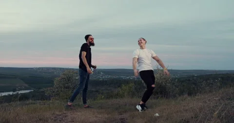 Two friends are having fun in the park at sunset, dancing and listening to music Stock Footage 138301424