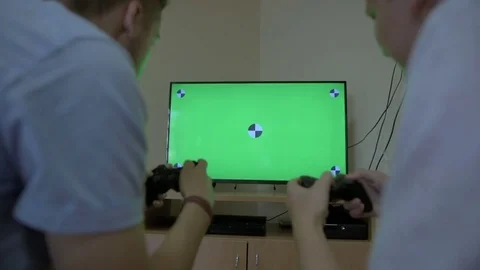 Two friends are playing video games and competing. Green screen tv Stock Footage 79403609