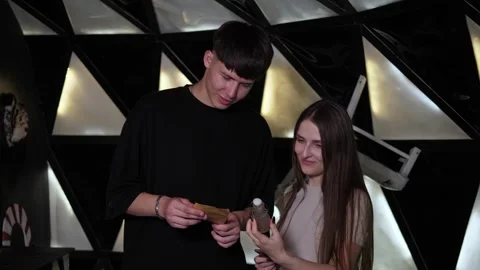 Two friends are reading a task on a note in a black and white dark quest room. Stock Footage 310655676
