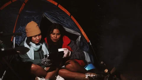 Two friends are seen Camping Outdoors at Night Stock Footage 323383605
