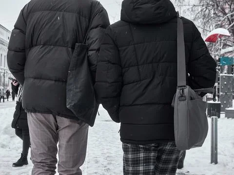 Two friends are walking down the street view from the back. Winter time Foto stock