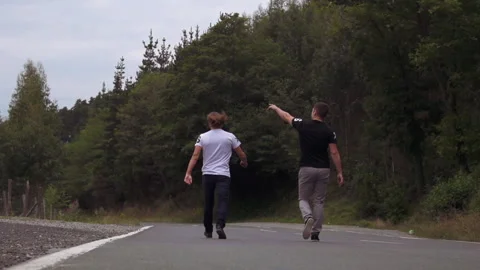 Two friends are walking on a mountain road in the summer Stock Footage 159307479