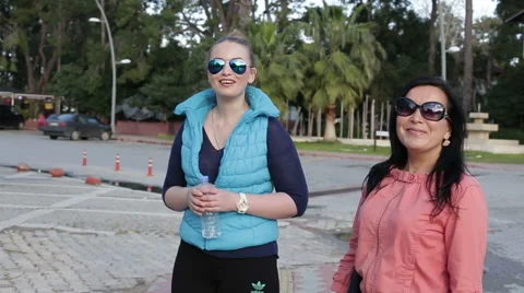 Two friends are walking in the park on a summer Stock Footage 64010774