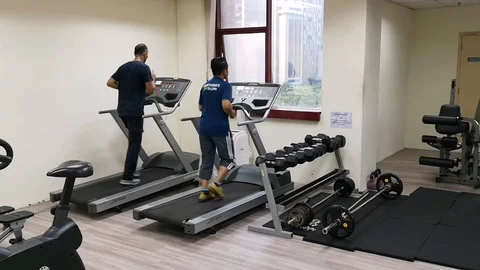 Two friends are working out to maintain their health by running on the treadmill Stock Footage 126081599