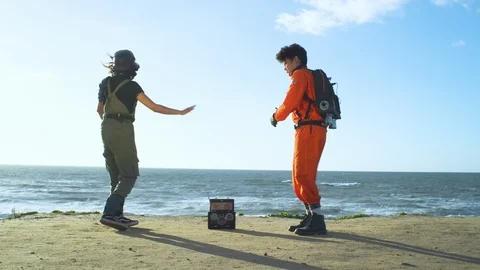 Two friends in astronauts suits dancing on the beach Stock Footage 108961798