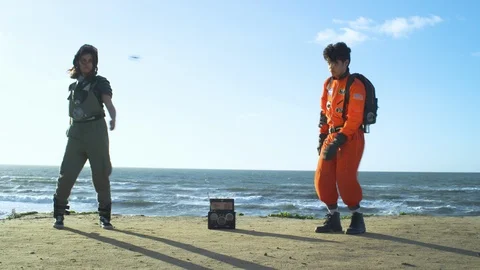 Two friends in astronauts suits dancing on the beach Stock Footage 108962068