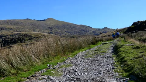 Two friends with backpacks walking up the Rhyd Ddu path to Snowdon Vídeos de archivo 166381327