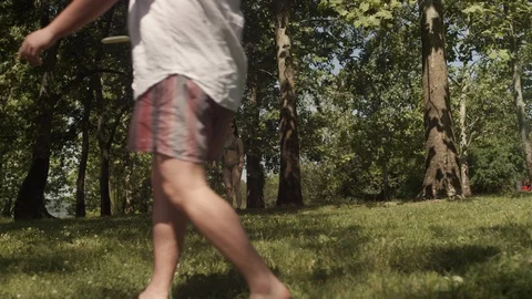 Two friends in bathing suits toss a frisbee back and forth with a rack focus Stock Footage 116774696