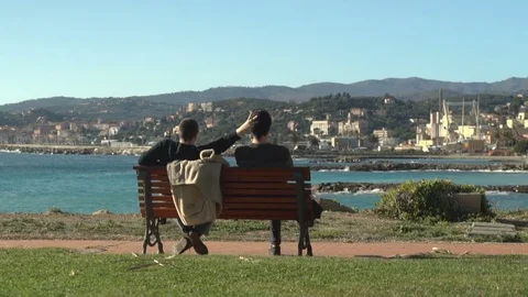 Two Friends on a Bench by the Sea Stock Footage 83388742