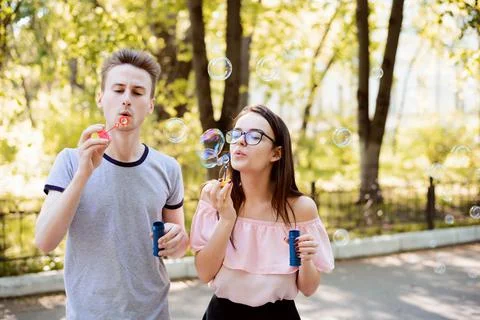 Two friends blowing soap bubbles Stock Photos