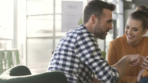Two friends browsing smartphone together during meeting at cafe Stock Footage 70808967