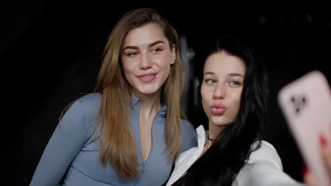 Two friends capturing a selfie, one making a duck face, sharing a light-hearted Stock Footage 268742838
