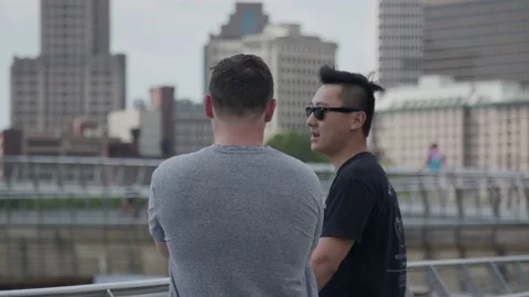 Two Friends Casually Talking With Providence City in the Background Stock Footage 154595091