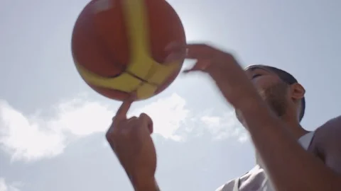 Two friends chatting as one spins a basketball on his finger Stock Footage 79605820