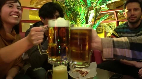 Two friends clinking two mugs of beer toasting to meet after years with several Stock Footage 164445936