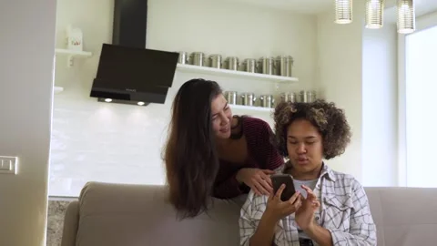 Two friends communicate with each other with smiles. African American and Asian Stock Footage 162369594