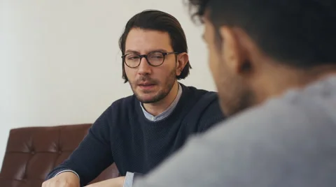 Two Friends Conversing on Stylish Sofa Indoors Stock Footage 59785217