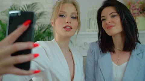 Two friends of different ages take selfies , Modern women in stylish suits pose Stock Footage 136510208