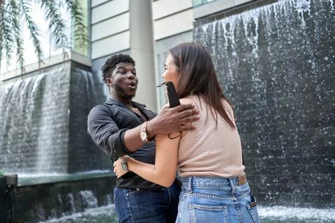 Two friends of different ethnicities meet again in a shopping mall Stock Photos
