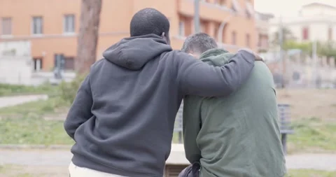 Two friends discuss sensitive issues and hug for support from behind Stock Footage 333197674