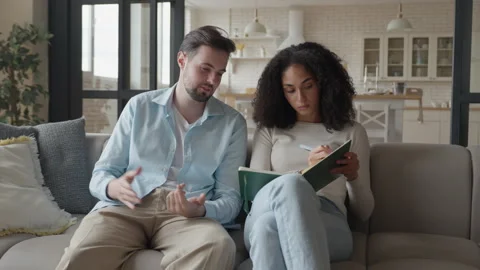 Two Friends Discussing Ideas, Taking Notes In Cozy Home Interior Видео 303758846