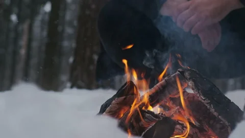 Two friends enjoy the fire at camping in the winter woods, making a fire Stock Footage 148637404