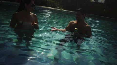 Two friends floating their beer cans in the pool at a country house in the Stock Footage 170021768